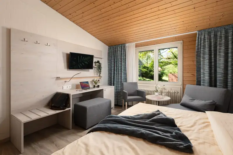 Zimmer mit Doppelbett, Schreibtisch und Flat-TV
